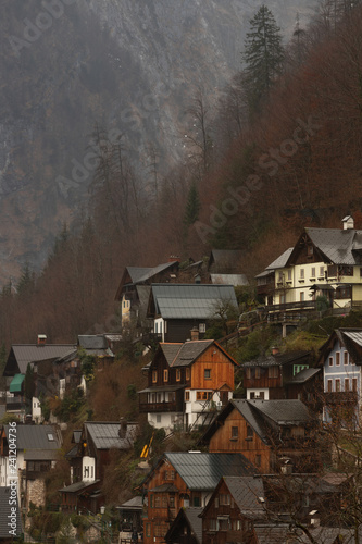 Wooden houses surrounded by mountains in Hallstatt, Austria on a rainy, winter day