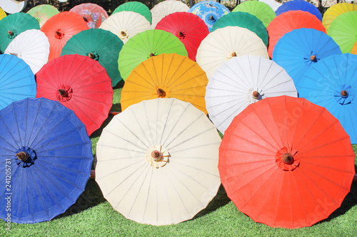 Colorful multicolored paper umbrella group on grass floor  decoration for background