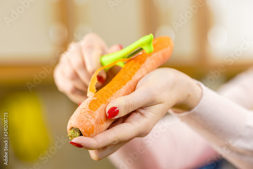 Woman peeling carrot vegetable