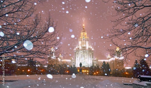 Snowfall in evenng winter campus of famous Russian university with snowed evergreen trees photo