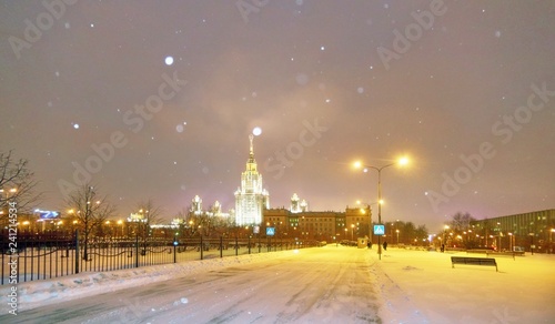 Snowfall in evenng winter campus of famous Russian university with snowed evergreen trees