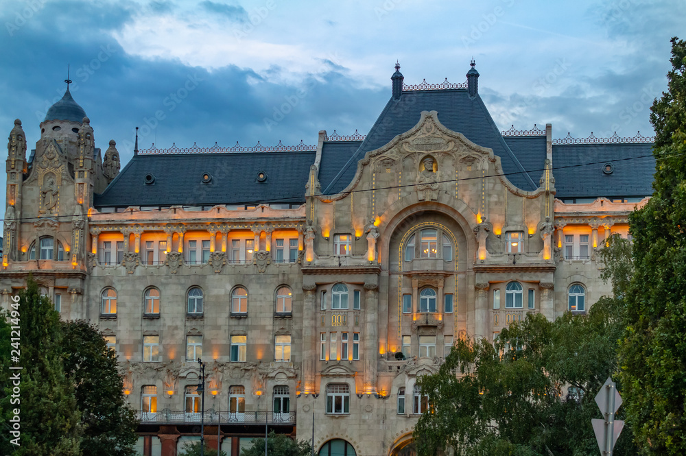Obraz premium Beautiful old building in the city of Budapest in the evening surrounded by trees