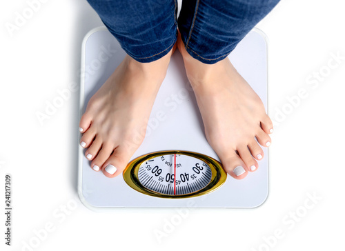 Female feet weighing scale on a white background isolation, top view