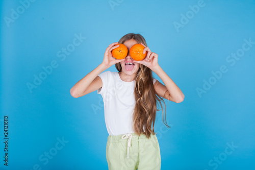small beautiful girl holding a ripe oranges healthy food