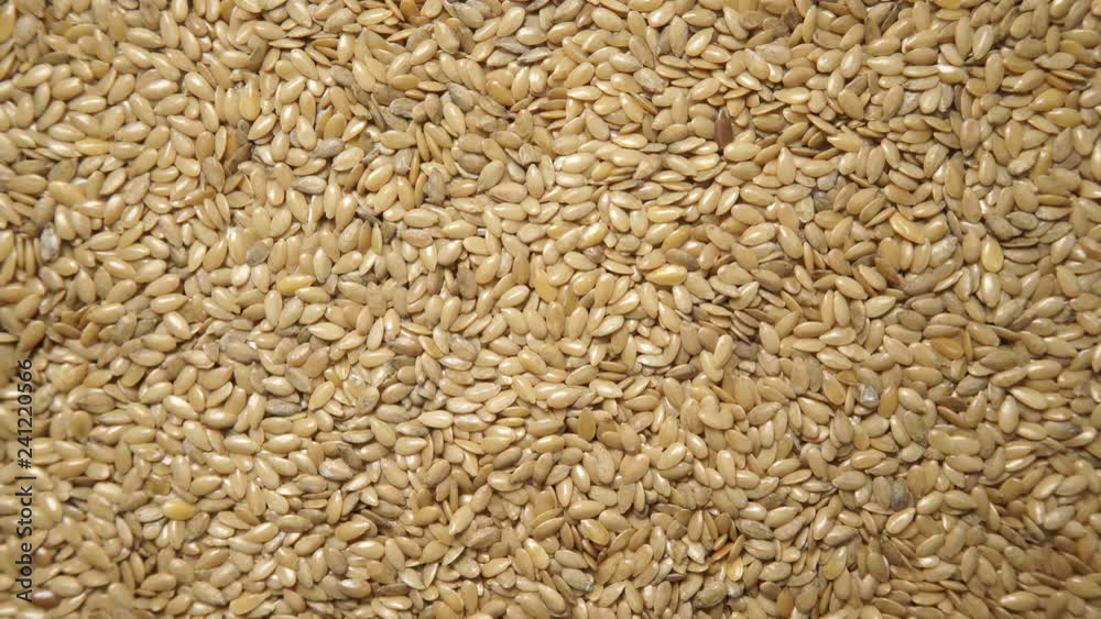 Golden raw flax seeds linseed as natural food background or grain texture. Flaxseeds full of omega 3 fatty acids. Top down view. Healthy diet organic nutrition. Golden raw flax seeds linseed as natural food background or grain texture. Flaxseeds full of omega 3 fatty acids. Top down view. Healthy diet organic nutrition.