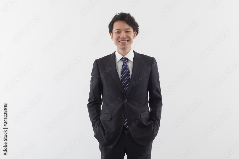 A young Asian business man standing with smile A young Asian business man standing with smile