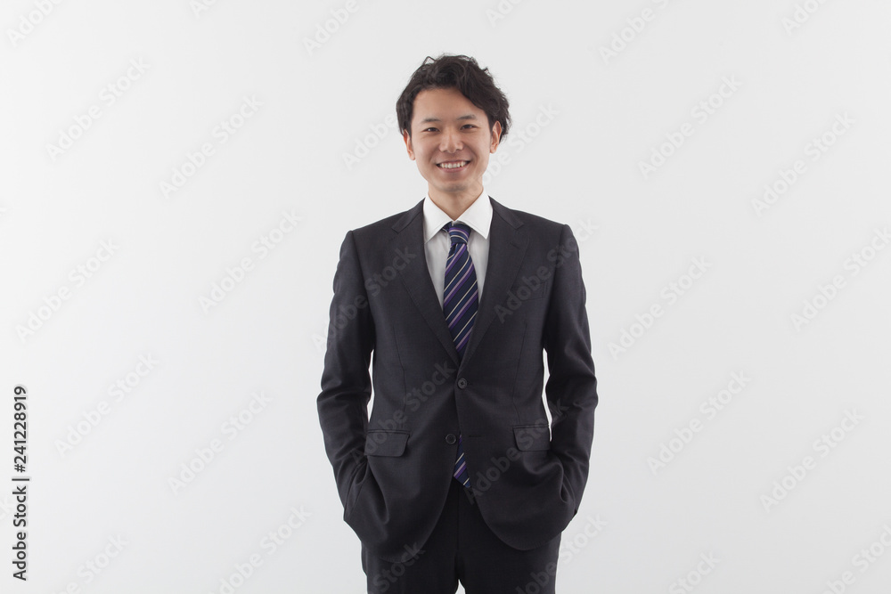 A young Asian business man standing with smile A young Asian business man standing with smile