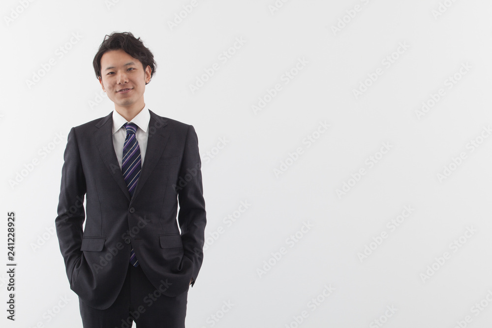 A young Asian business man standing with smile A young Asian business man standing with smile