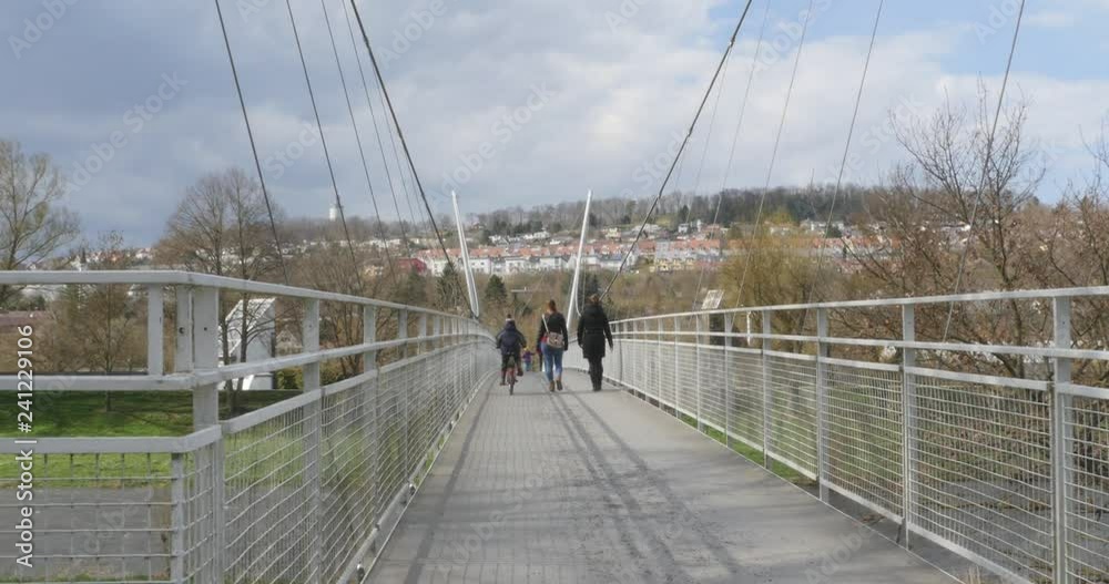 Suspension Bridge crossing with bike and two women Suspension Bridge crossing with bike and two women