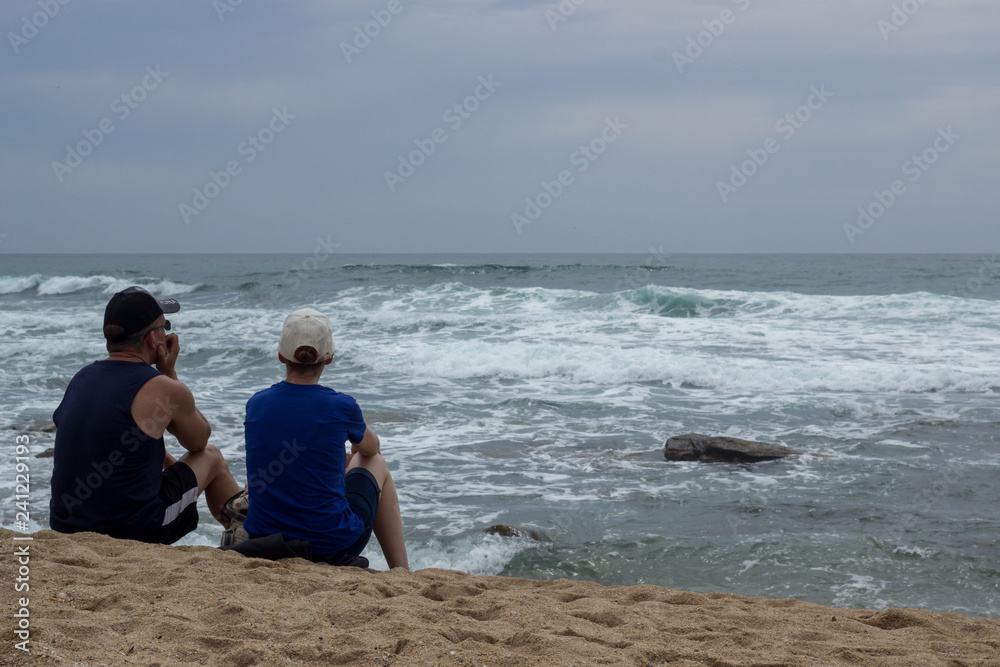 elderly couple sitting on the beach enjoying the sea view 