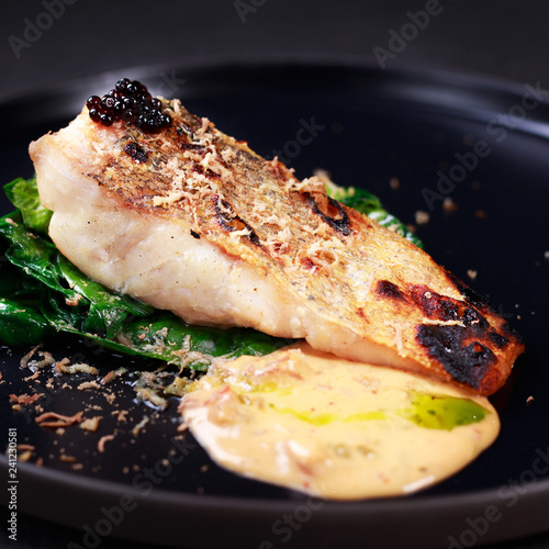 grill pub and fish restaurant menu, delicious pikeperch with spinach garnishing and sauce, grilled zander. diet food, proper nutrition, seafood, vegetarian, pescetarian photo