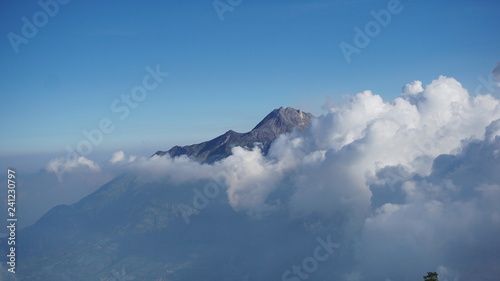 Mountain above the clouds against blue sky