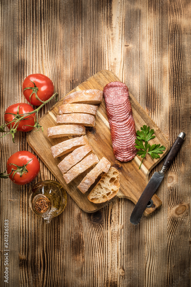 Italian ciabatta bread cut in slices with salami.
