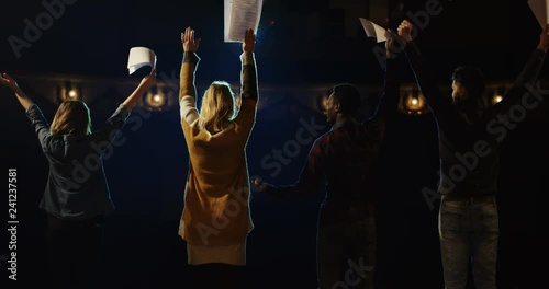 Slow motion of actors and actresses bowing to audience in a theater