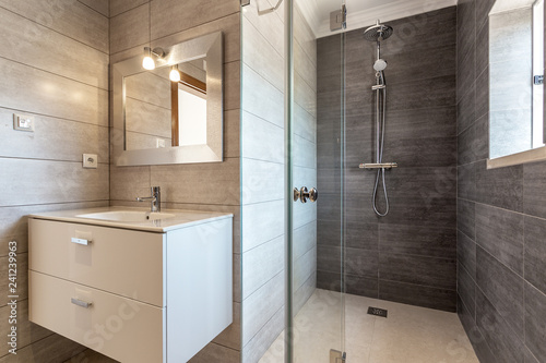 Photographie Modern bathroom with shower and washbasin for hygiene.
