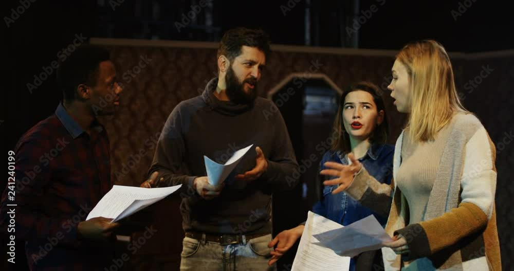 Medium shot of actors and actresses arguing during rehearsal in a theater Medium shot of actors and actresses arguing during rehearsal in a theater