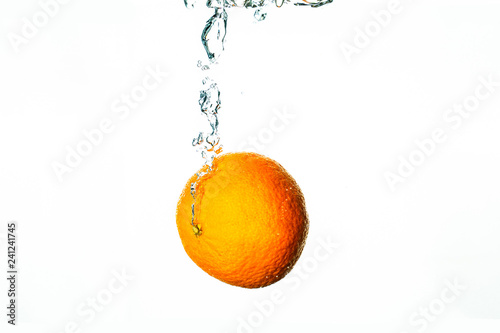 Fresh fruit dives into water with bubbles
