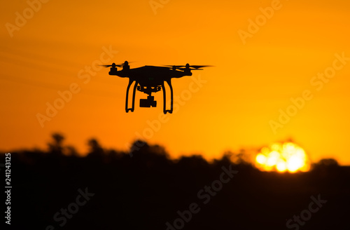 Silhouette of drone flying at sunset