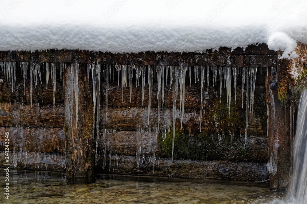 Fototapeta premium Eiszapfen vor Holz