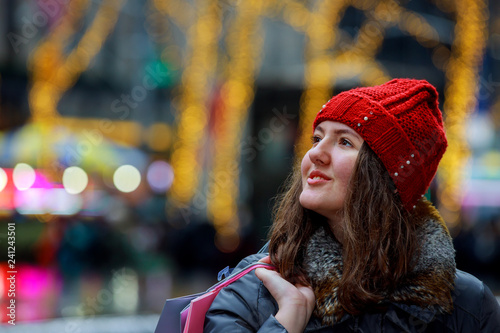 Female teenager hands holding a shopping bags, colorful lights bokeh