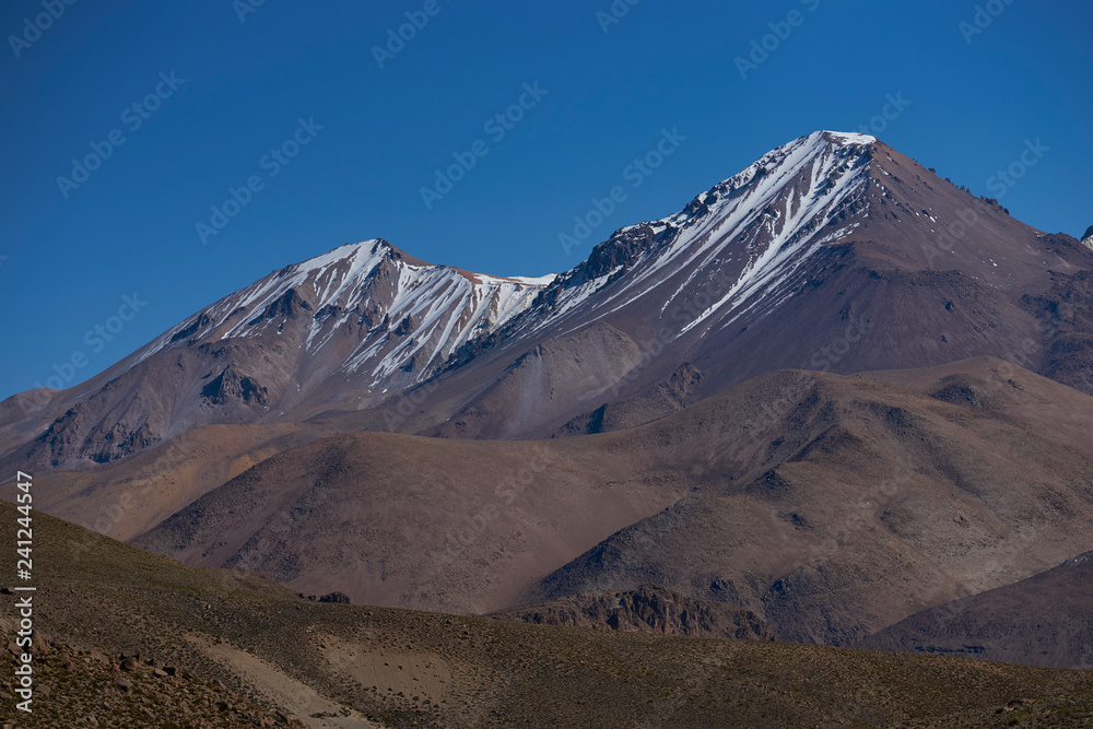 Snow capped peaks and rugged landscape of the altiplano, around 4000 metres above sea level, in Lauca National Park, Chile. 