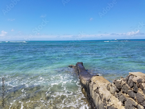 Lava rock wall that jetty into the ocean at Makalei Beach photo