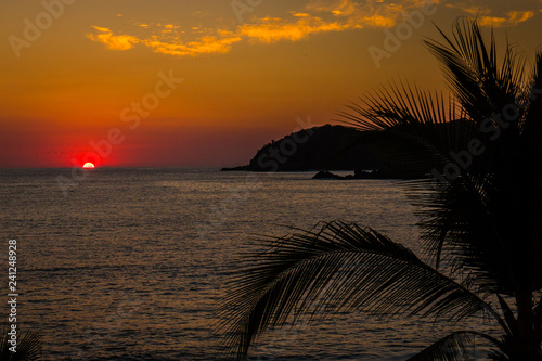 Beautiful sunset with palms and an island at Club Med, Ixtapa, vacation resort in Mexico