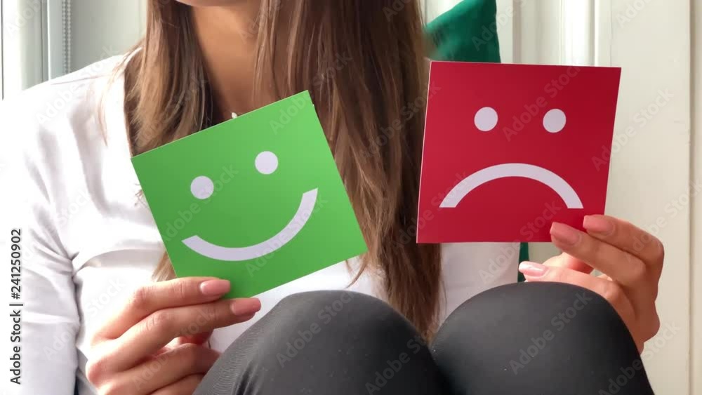 Concept of choice. A beautiful woman hold two smiles in her hands