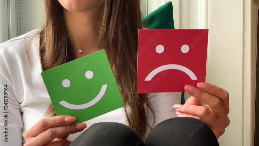 Concept of choice. A beautiful woman hold two smiles in her hands