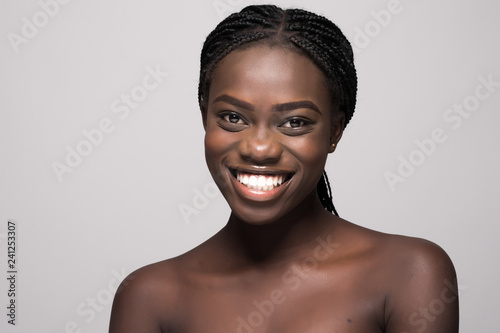 Portrait of young beautiful african woman touching her face isolated over white background. Cleaning face, perfect skin. SPA therapy, skincare, cosmetology, hair removal or plastic surgery concept