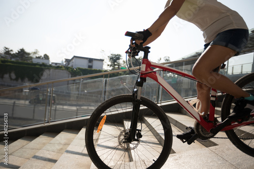 Riding bike down ramp of overpass in city