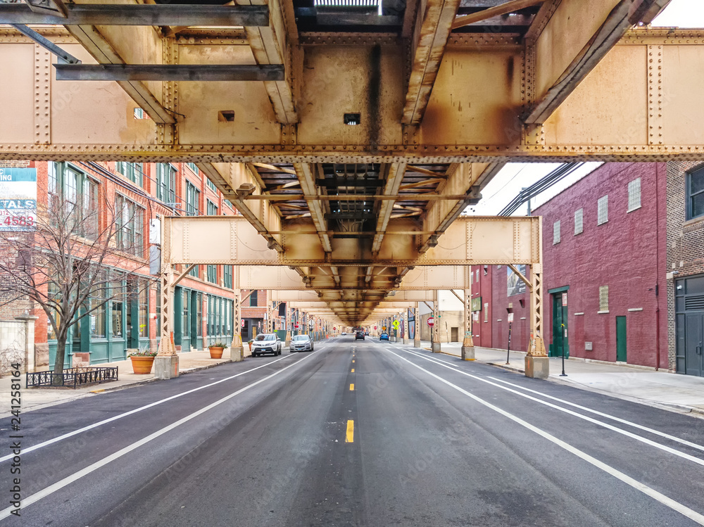 Fototapeta premium Lake Street pod podwyższonym pociągiem w dzielnicy Fulton Market, wschodnia perspektywa. Główne ulice w Chicago, ulice w Illinois.