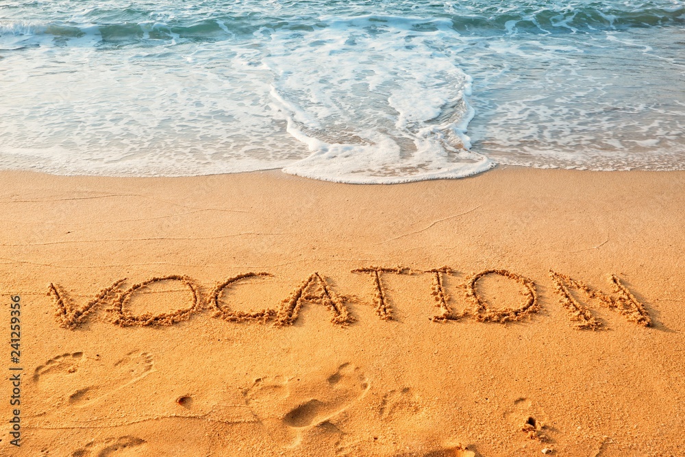 Fototapeta premium The word of vocation writing on sand beach with waves blue ocean.