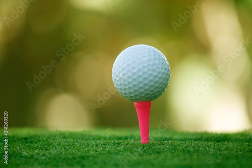 Golf ball on tee in beautiful golf course at bokeh background. Golf ball on green in golf course