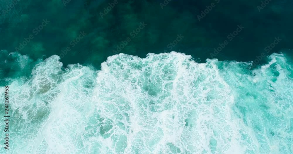 Top down aerial view of abstract ocean waves crashing creating unique patterns