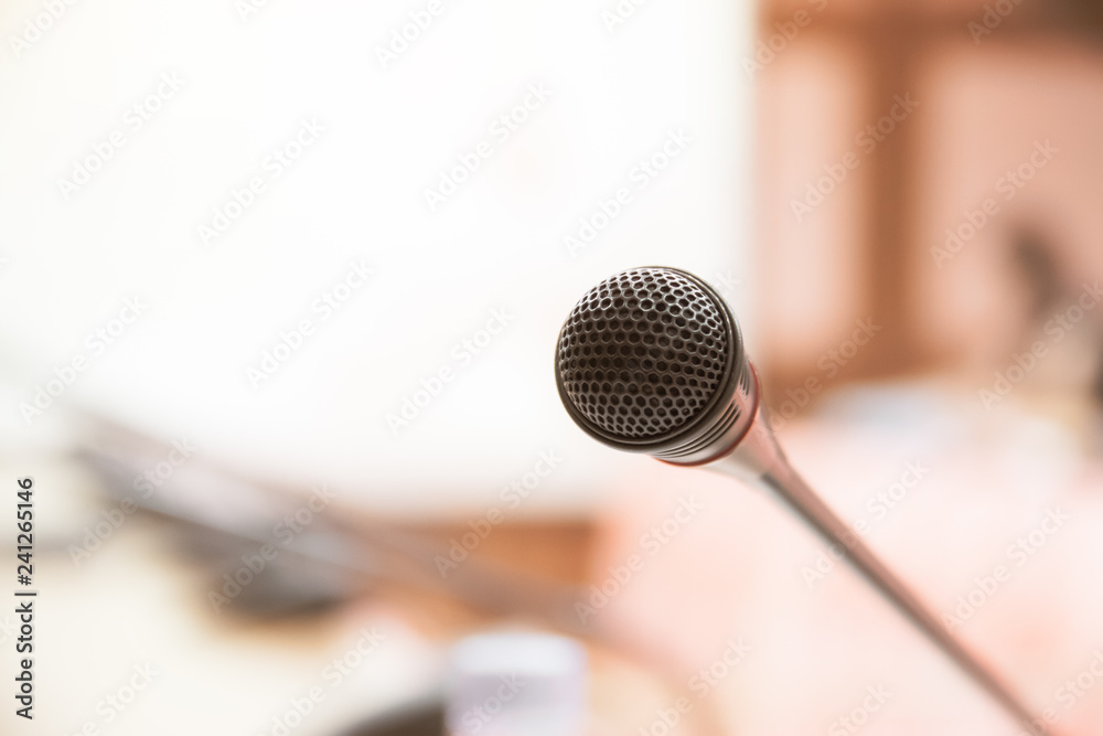 Mini Microphone on abstract blurred conference hall for speaker on stage in seminar room background, Business meeting and education in teaching classroom concept Mini Microphone on abstract blurred conference hall for speaker on stage in seminar room background, Business meeting and education in teaching classroom concept