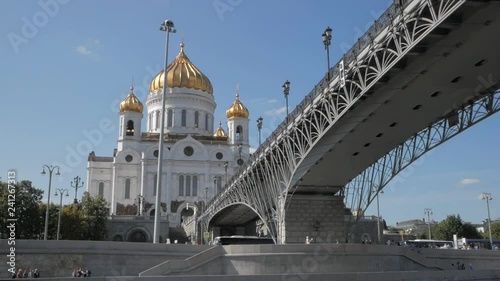 Boat moving under Patriarshy bridge, along Moskva river embankment with Christ the Saviour Cathedral with golden domes