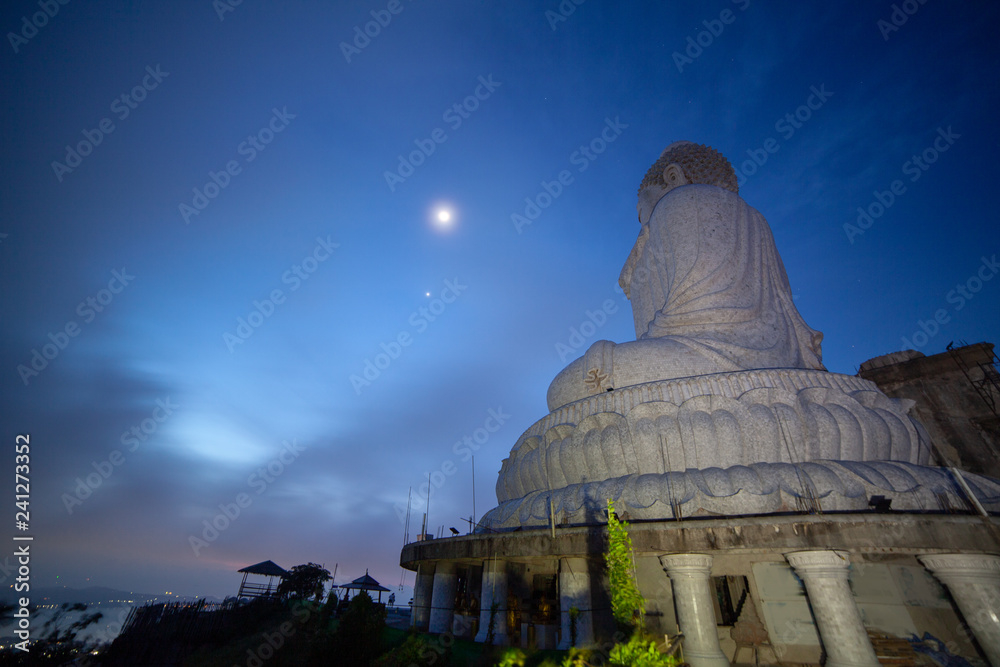 Fototapeta premium moon and star above the head of Phuket big Bubbha brfore sunrise
