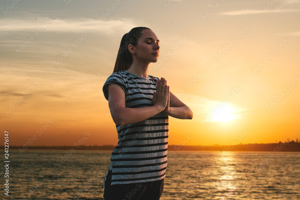 A girl practices yoga or meditation or searching for a soul against the backdrop of a beautiful sunset. Solitude and unplugged