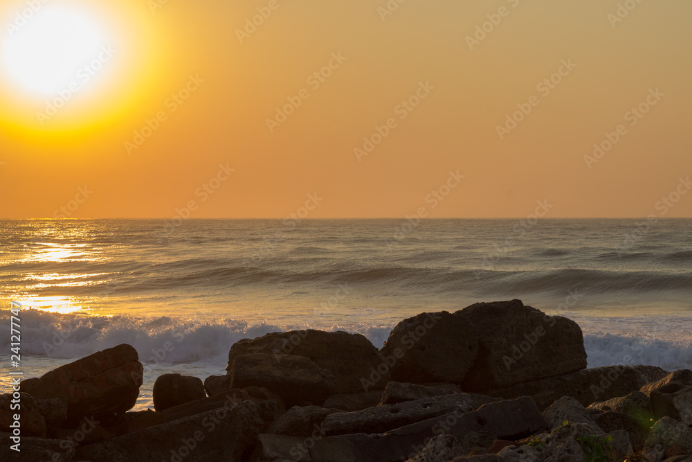 sunrise over the indian ocean with rock in foreground 