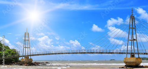 Obraz na plátne Bridge to island, ocean and sun in blue sky (Matara, Sri Lanka) Wide photo