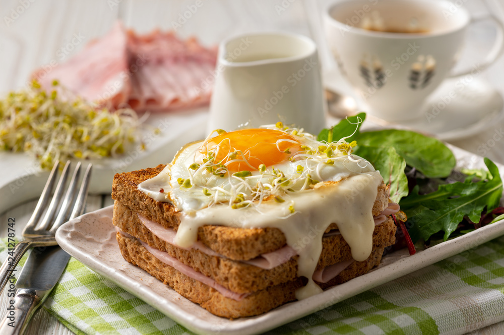 Croque madame, hot french toasts with ham , cheese and egg. 
