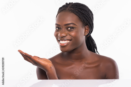 Skin care beauty woman showing empty palm with copy space for product. Excited and very fresh smiling African emale beauty model isolated on white background. photo