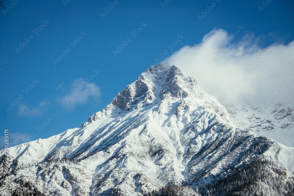 Epic snowy mountain peak with clouds in winter, landscape, alps, austria