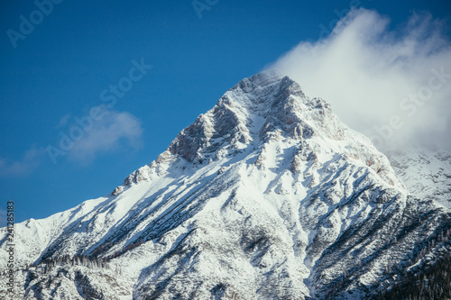 Epic snowy mountain peak with clouds in winter  landscape  alps  austria
