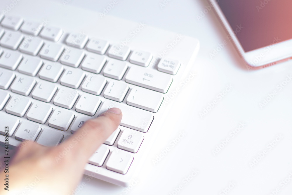 hand finger push on enter keyboard button and mobile phone on white background in network business concept hand finger push on enter keyboard button and mobile phone on white background in network business concept