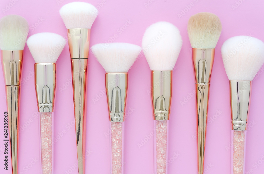 Set of makeup brushes on pink colored composed background. Top view point, flat lay. Set of makeup brushes on pink colored composed background. Top view point, flat lay.