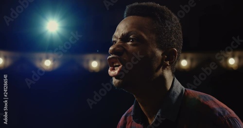 Medium close-up shot of an actor performing a monologue in a theater while holding his script