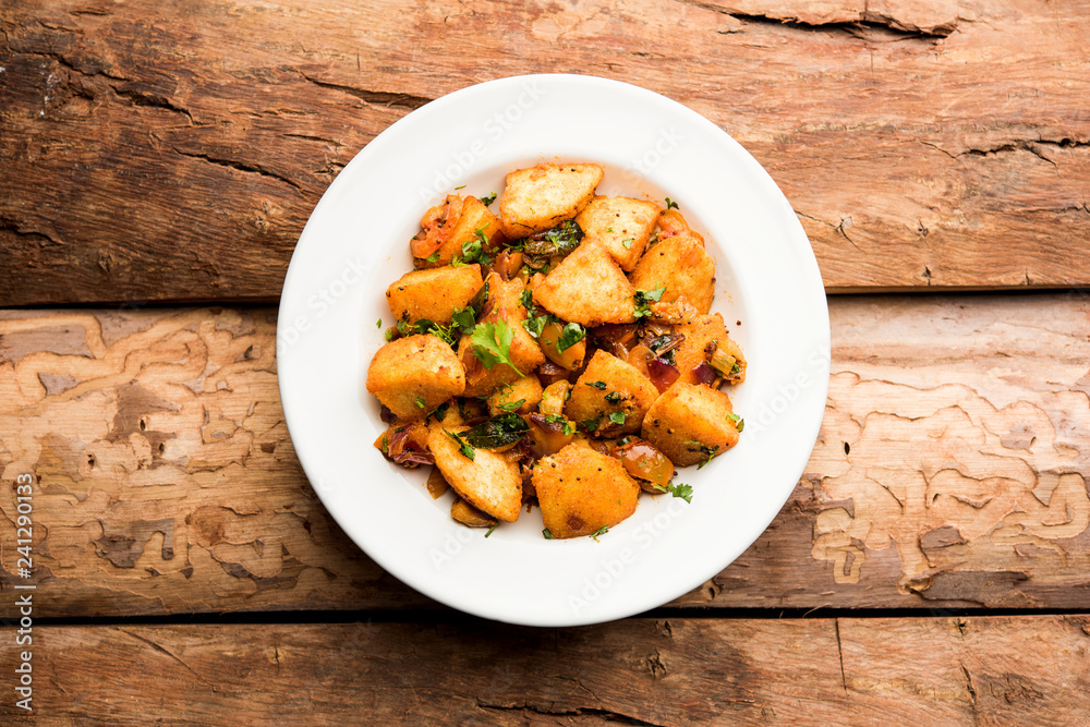 Masala fried Idlies or Idli fry - south indian Snack made using with leftover idly served with tomato ketchup. selective focus Masala fried Idlies or Idli fry - south indian Snack made using with leftover idly served with tomato ketchup. selective focus