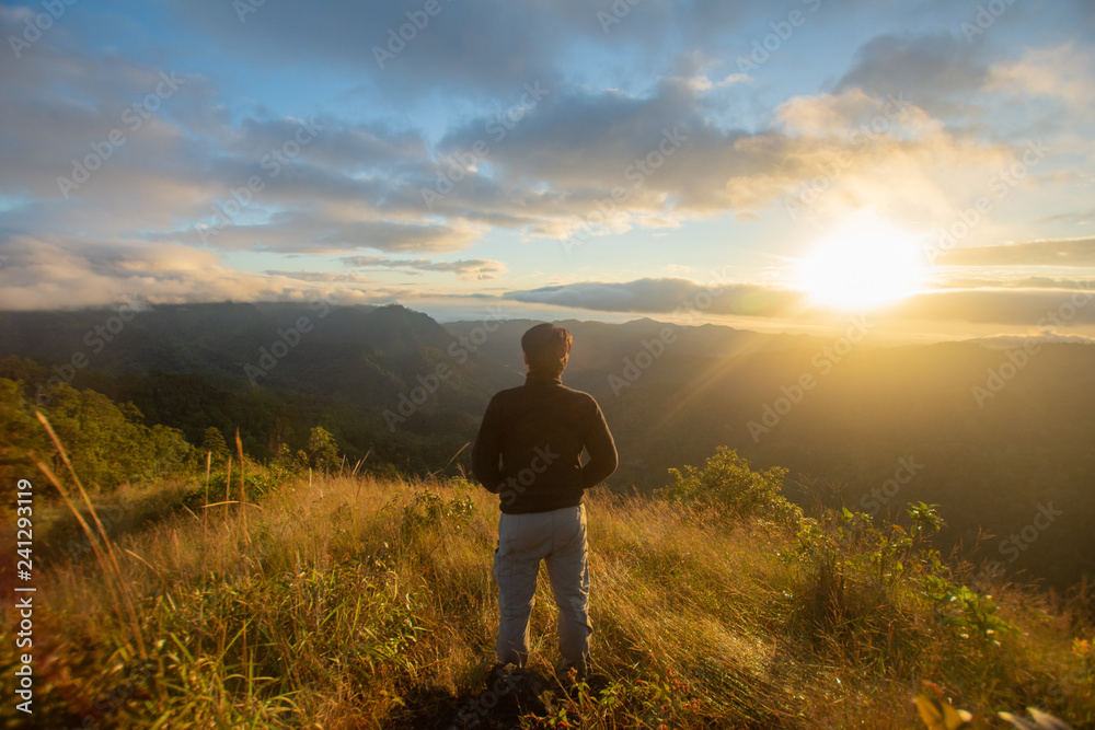 rear of happy woman stand on top mountain looking view with sunrise and mist at Doi Langka Luang, Chiang Rai province. soft focus. rear of happy woman stand on top mountain looking view with sunrise and mist at Doi Langka Luang, Chiang Rai province. soft focus.